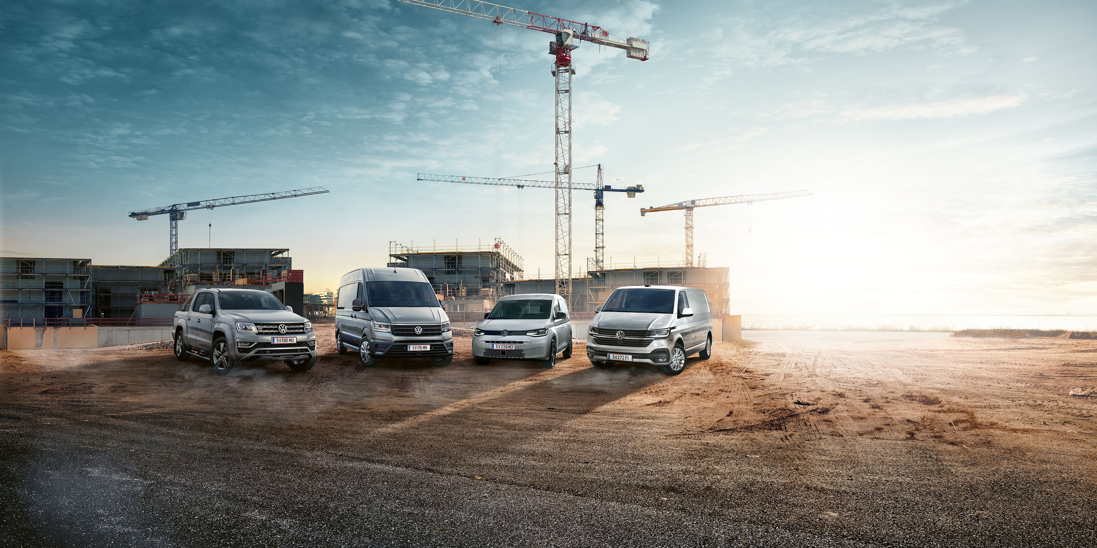 Verschiedene VW Nutzfahrzeug Modelle auf einer Baustelle