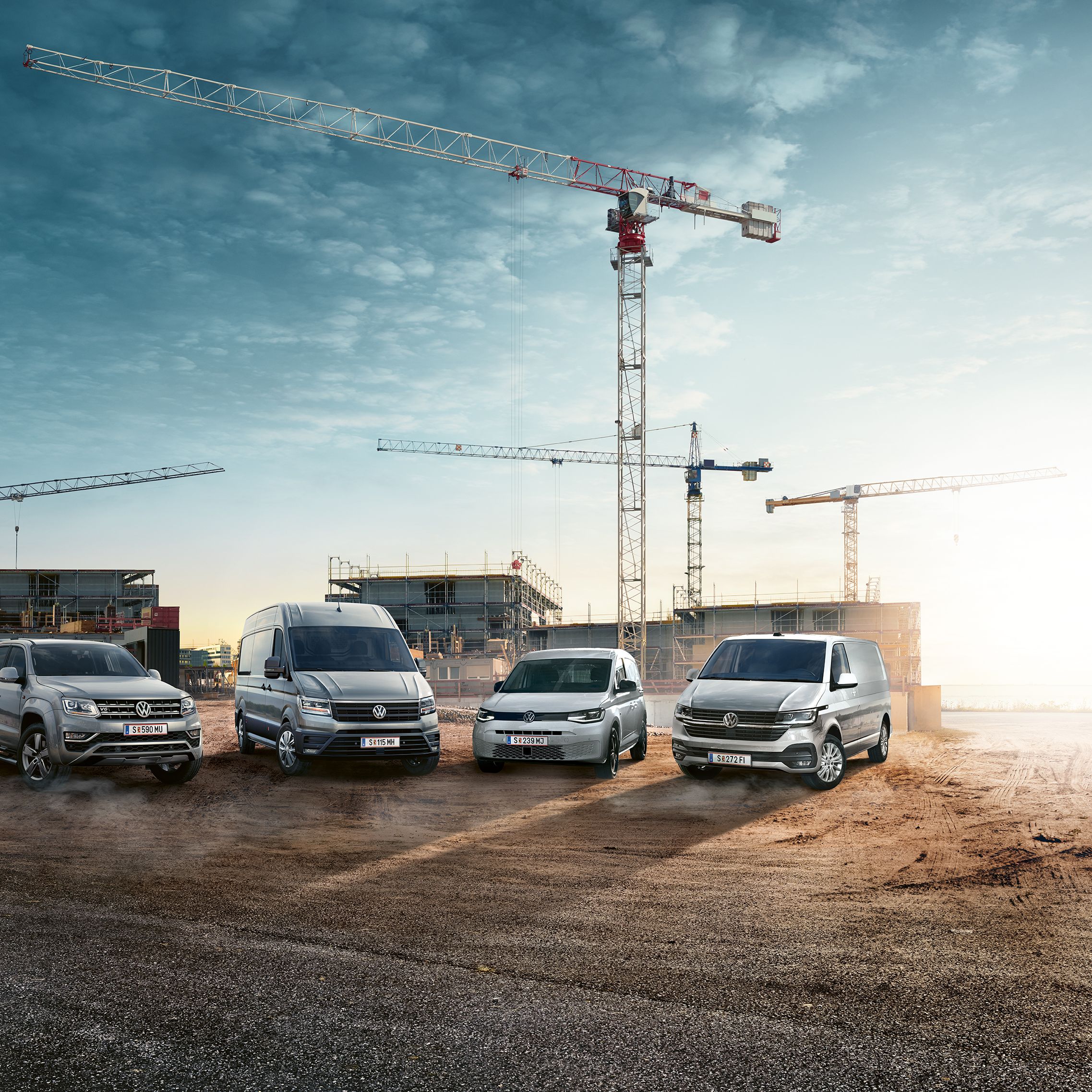 Verschiedene VW Nutzfahrzeug Modelle auf einer Baustelle
